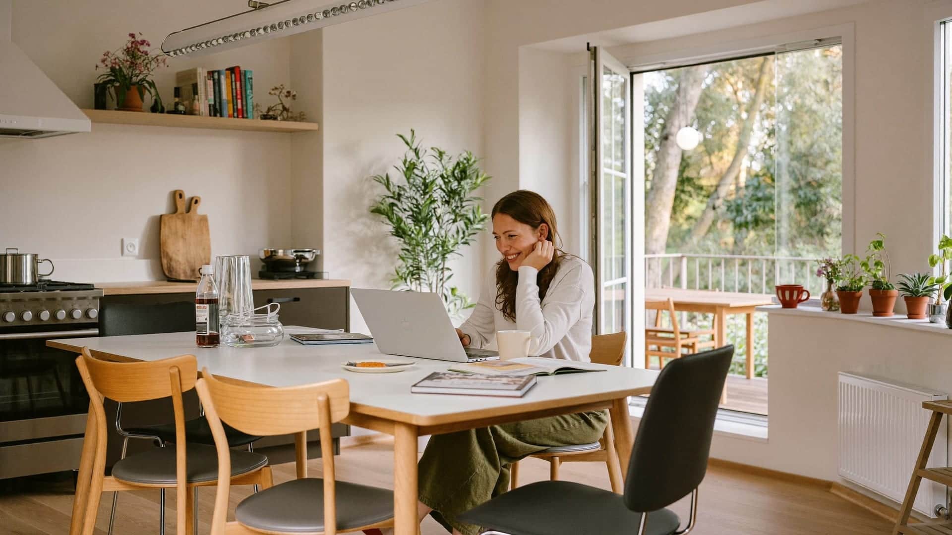 Vrouw aan de keukentafel met laptop